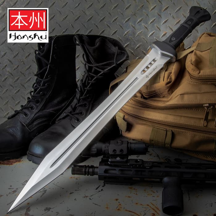 Honshu Gladiator sharp silver sword with black slip grip handle point lying on top of tactical bag next to combat boots
