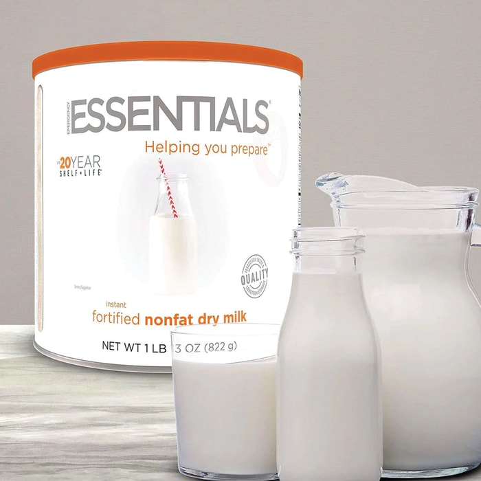 Emergency Essentials Instant Dry Milk shown in its container and reconstituted in glass containers