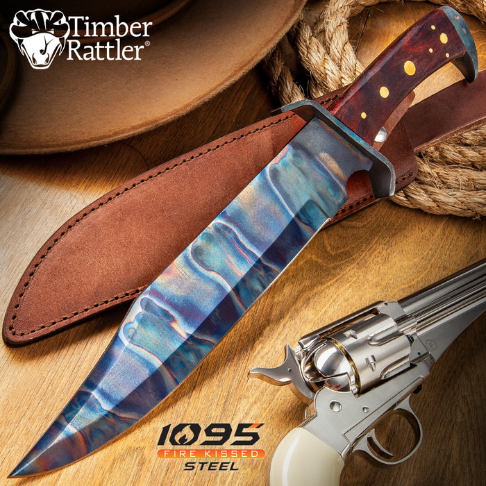 The Timber Rattler Gunslinger Bowie Knife, shown on a background with sheath and weapon, has a fire kissed carbon steel blade.