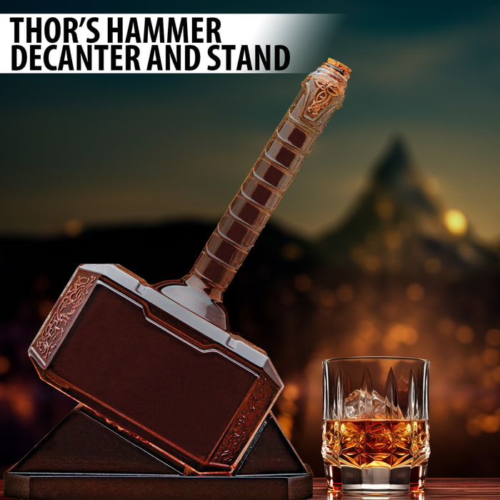 This image shows a glass decanter in the shape of Thor's hammer. It features a cork closure top and a wooden desk stand.