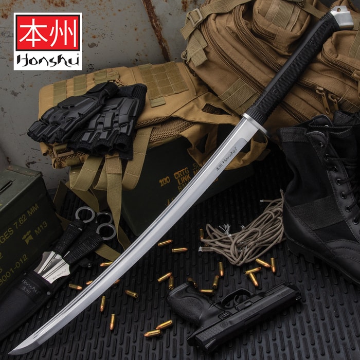 Honshu Boshin Wakizashi shown leaning against various pieces of tactical gear and weapons. 
