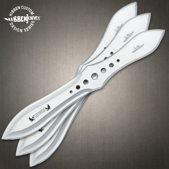 Gil Hibben Competition Throwing Knife Triple Set shows three stainless steel knives, brown sheath, and a target.