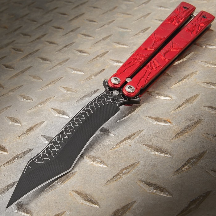 The Red Dragon Butterfly Knife has dragon scale detailing on the stainless steel blade and molded red steel handle.