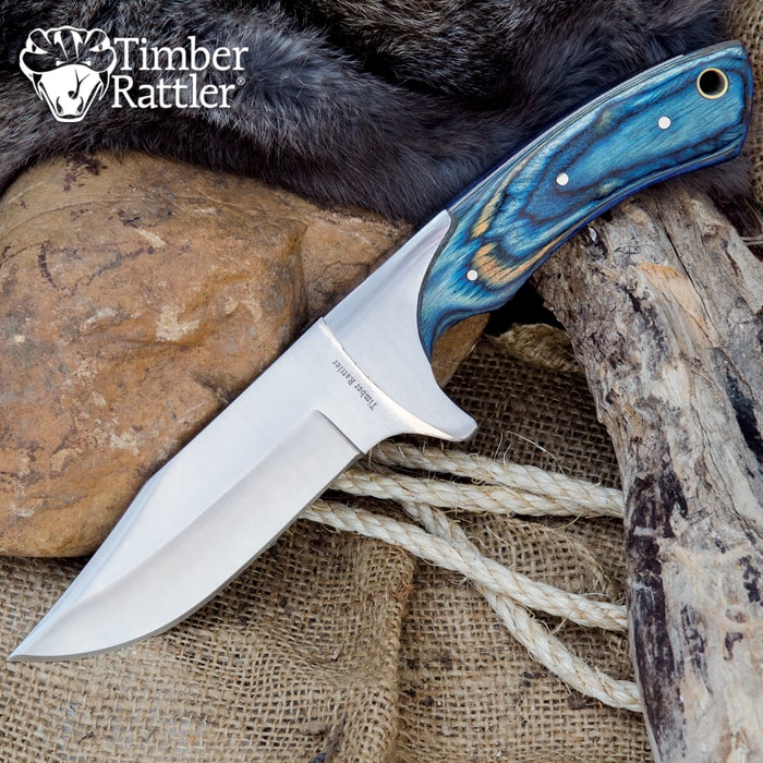 Knife with blue handle on rocks and fur