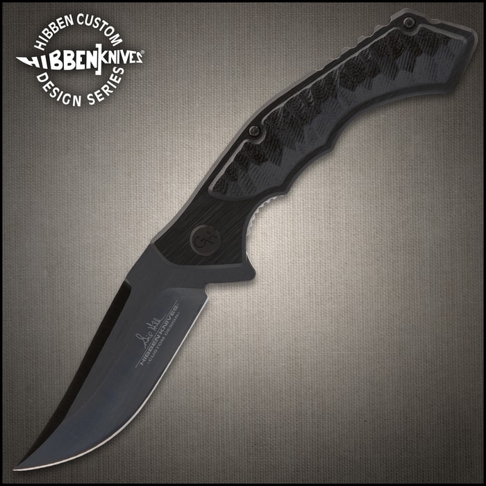 Blacked-out matte "Gil Hibben" Pocket knife with a single-edged blade and scalloped details on a wood background.