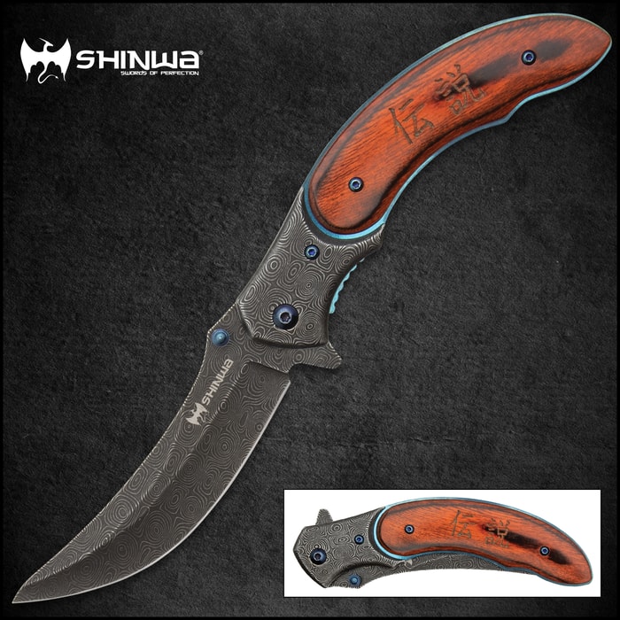 Shinigami bloodwood pocket knife with "raindrop patterned" blade and metallic blue accents on a background of orange toned bamboo. 
