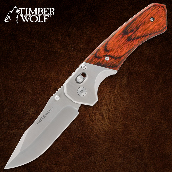 Folding knife with wood handle on brown background